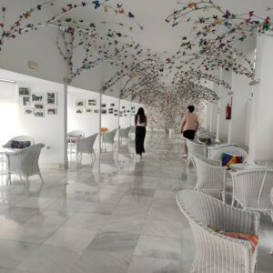 Galería de las mariposas del balneario, con techos cubiertos de ramas y mariposas de colores