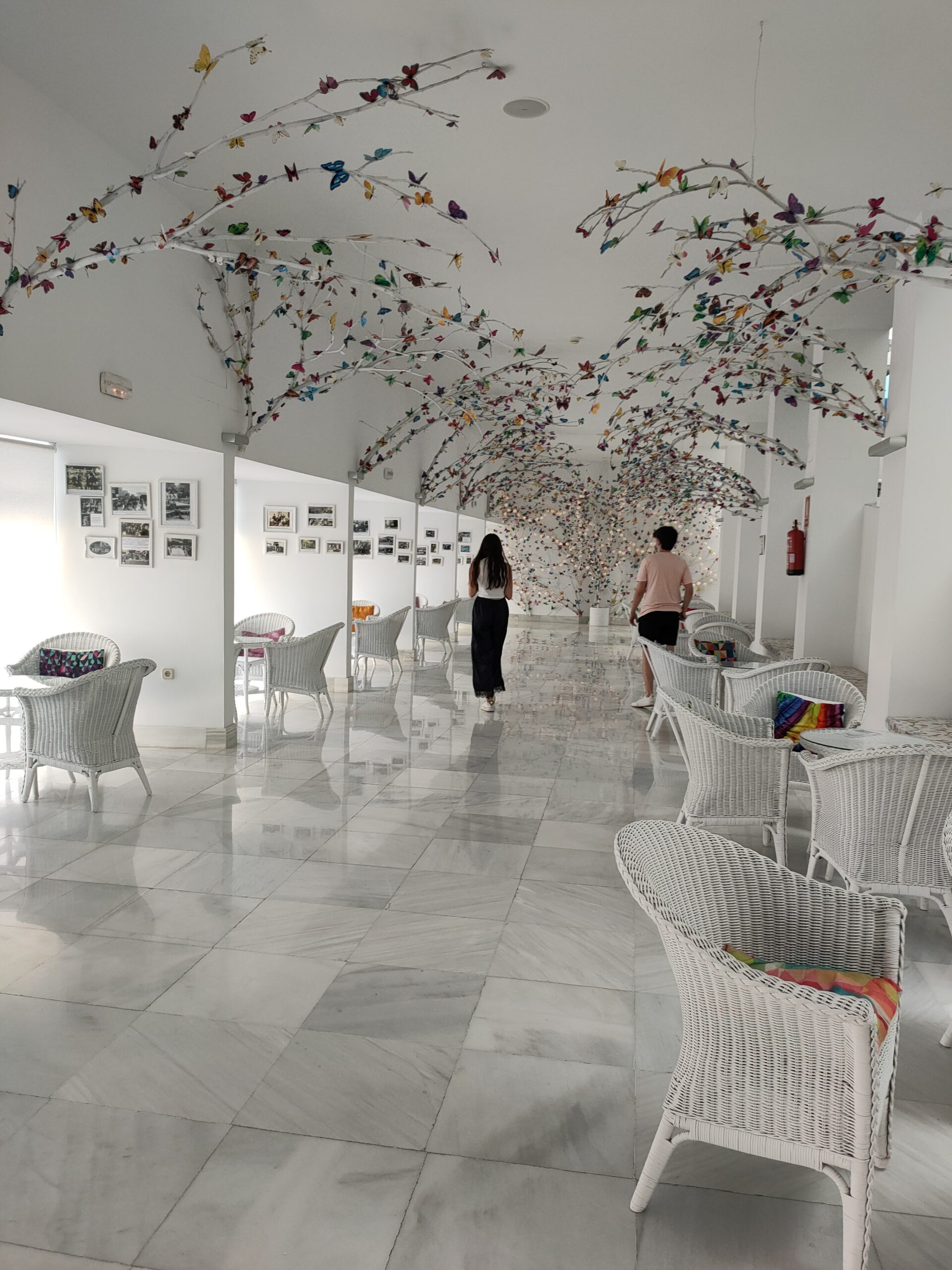 Galería de las mariposas del balneario, con techos cubiertos de ramas y mariposas de colores