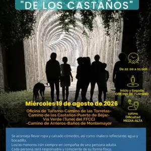 Grupo de personas caminando de noche por el túnel de la Vía Verde en la Ruta nocturna de los Castaños